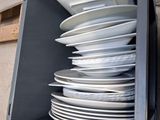 a stack of white plates in a gray box
