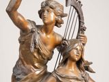 bronze statue of two women with harps on a marble base