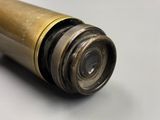 a close up of an old brass telescope lens on a white surface