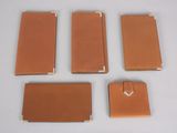 four pieces of brown leather are arranged on a white surface