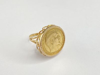 a close up of a gold coin ring on a white surface