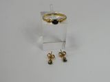a pair of earrings and a ring on a white surface