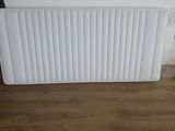 un radiateur blanc posé à même le sol près d'un mur
