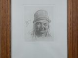 portrait of an old man with a hat and mustache in a wooden frame