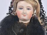 a doll that is wearing a black dress and a black hat