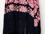 a pink and black shawl hanging on a white wall
