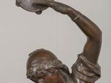 bronze statue of a woman holding a tambour on her head