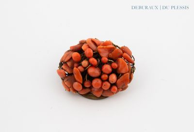 a red bead on a white surface with a white background