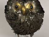 une sculpture en métal représentant un hibou aux grands yeux