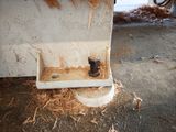 a dirty sink in the middle of a pile of straw