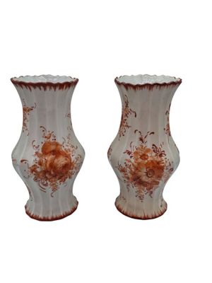 two vases sitting side by side on a white surface