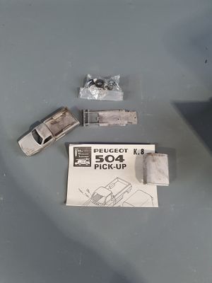 a small toy car sitting on top of a table next to a piece of paper