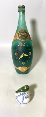une bouteille verte ornée d'une horloge, à côté d'un petit oiseau