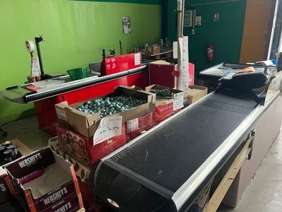 un tapis roulant dans un entrepôt rempli de cartons de boissons gazeuses
