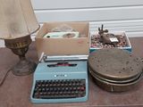 une machine à écrire bleue posée sur une table, à côté d'une lampe