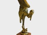 sculpture en bronze représentant un oiseau, posée sur un socle en bois