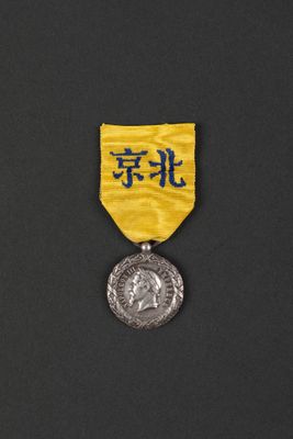 a close up of a medal on a black surface with a yellow ribbon
