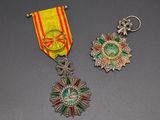 two medals and a medal on a table with a gray background
