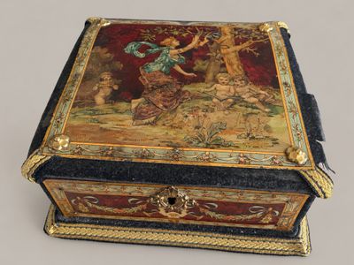 a small box with a painting on it on a table