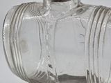 a glass bottle with a wooden base on a table