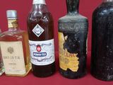 several bottles of liquor are lined up on a red table