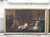 two paintings on the wall of a building that have food on it