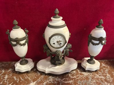 three white vases with a clock on them on a table