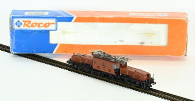 un petit train sur les rails, à côté d'une boîte dans son emballage