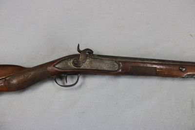 a close up of a rifle on a table with a white background