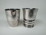 two silver cups sitting next to each other on a table