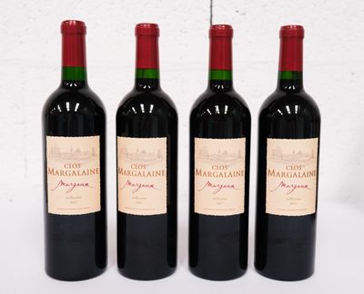 trois bouteilles de vin rouge sont alignées sur une surface blanche
