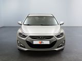 the front view of a silver car in a room with a white wall