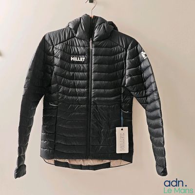black jacket hanging on a wall with a tag on it