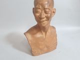 une petite statue représentant un homme assis sur une table