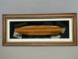 une photo d'une planche de surf en bois exposée dans une vitrine