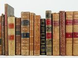 a lot of old books that are stacked on top of each other
