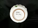 a white bowl with a brown rim on a black background
