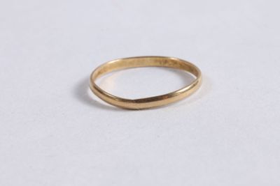 gros plan d'une bague en or sur une surface blanche