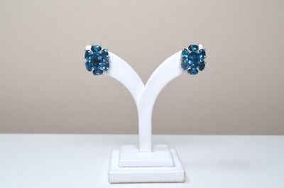 pair of blue crystal earrings on a white stand on a white table
