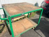 un chariot vert sur lequel est posée une table en bois