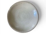 a white plate with a design on it on a white surface
