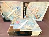 trois boîtes de maquettes d'avions posées sur une surface marron