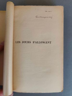un livre ouvert, tenu par une main devant lui