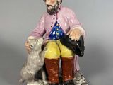 une figurine représentant un homme assis sur un banc avec un chien