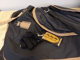 a black and tan duffel bag sitting on the floor