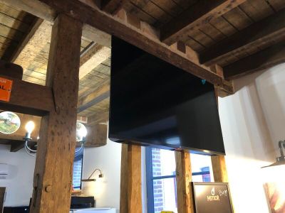 a television hanging from the ceiling in a room