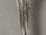 a silver spoon with a flower on it on a table
