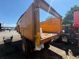 un camion-benne jaune garé sur un parking