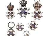 a group of six silver and gold medals and a cross