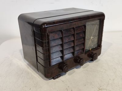 une vieille radio posée sur une table près d'un mur blanc